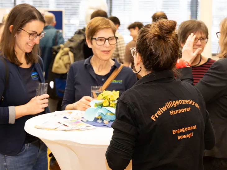Gäste im Gespräch an Stehtischen