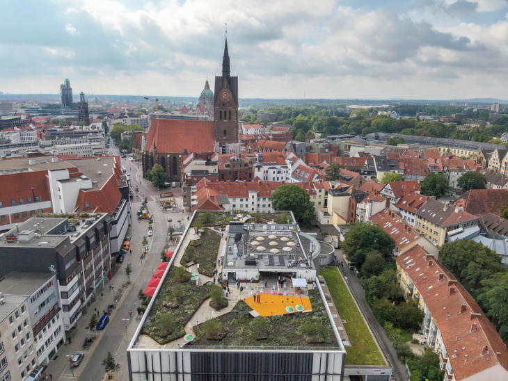 Blick auf ein begrüntes Parkhausdach von oben.