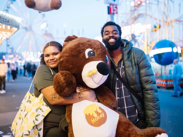 Ein Erwachsener und ein Kind mit einem großen Teddy.