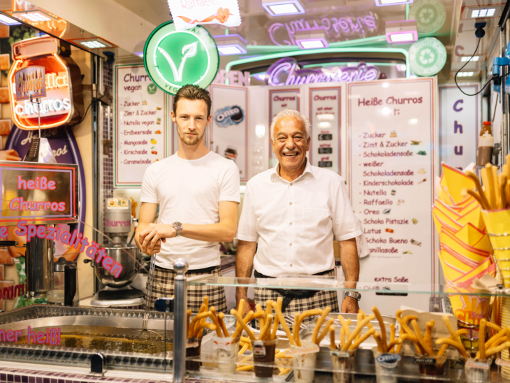 Zwei Männer hinter einem Churro-Stand-