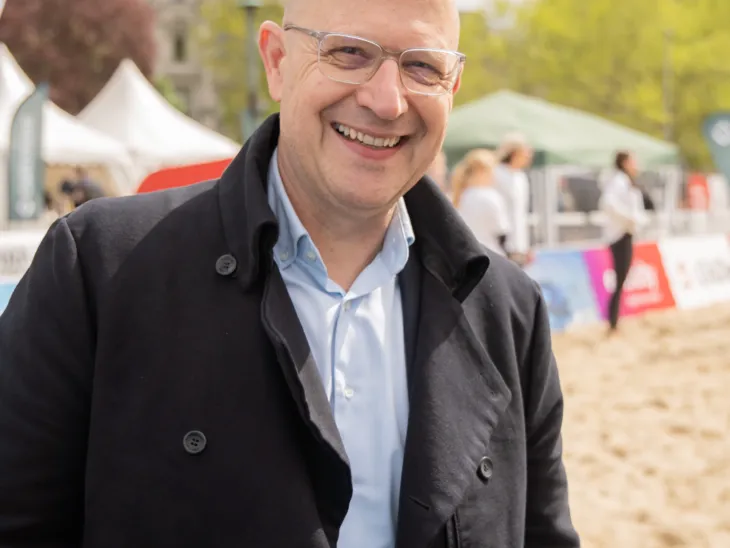Ein Mann steht vor einem Beachvolleyballfeld.