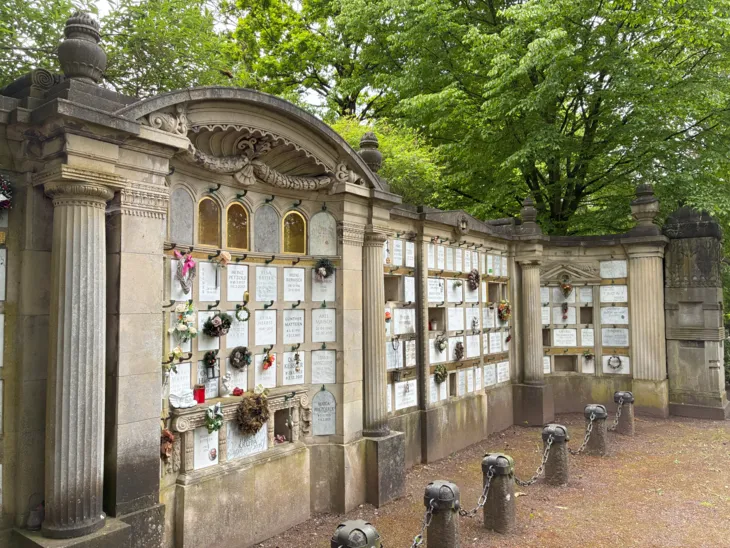 Eine Urnenwand auf einem Friedhof.
