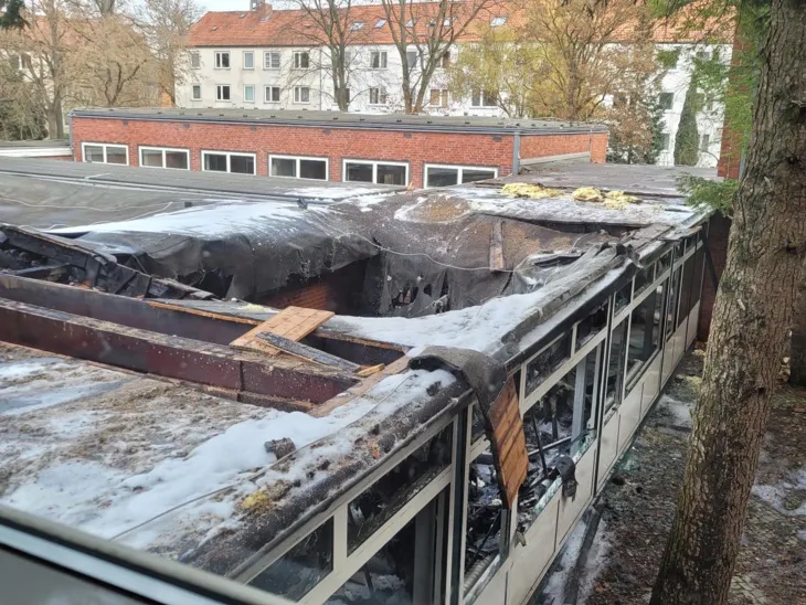 Ein antrazitfarbenes Flachdach auf einem flachen Gebäude, dessen Konstruktion an einer großen Stelle eingesackt ist.