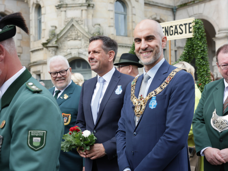Drei Männer in einem Festzug.