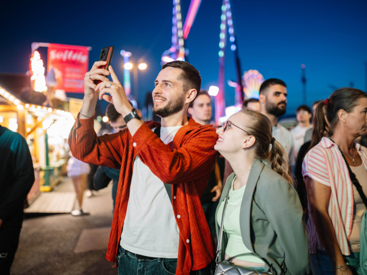 Menschen auf einem abendlichen Festplatz.