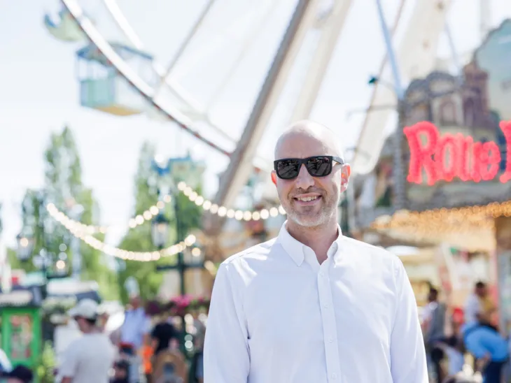 Ein Mann mit einer Sonnenbrille auf einem Festplatz.