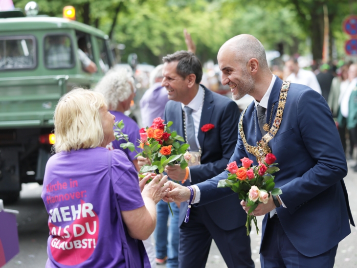 Zwei Männer beim Verteilen von Blumen.