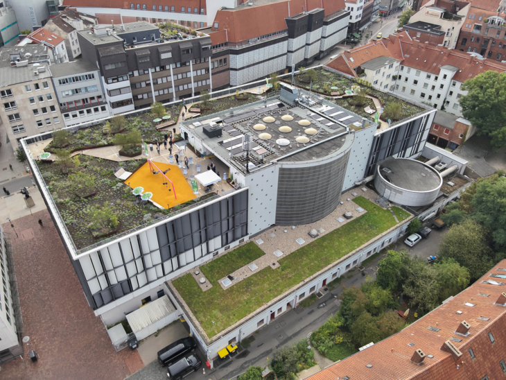 Blick auf ein begrüntes Parkhausdach von oben.