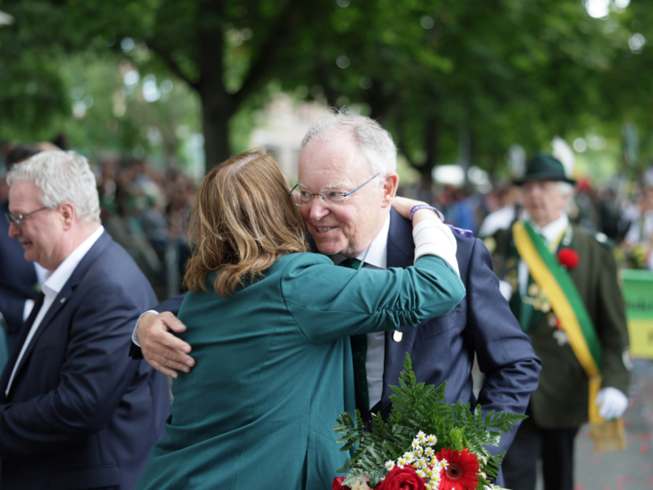 Zwei Menschen, die sich in einem Festumzug begrüßen.