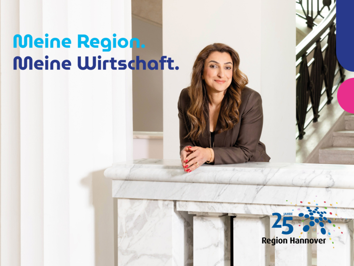 Eine Frau in Business-Kleidung lehnt an einem Treppengeländer.