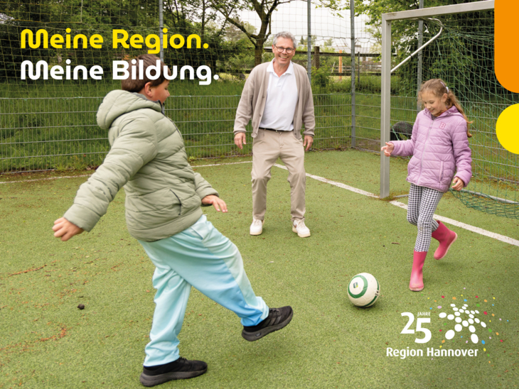 Ein Förderschullehrer spielt mit Kindern draußen Fußball.