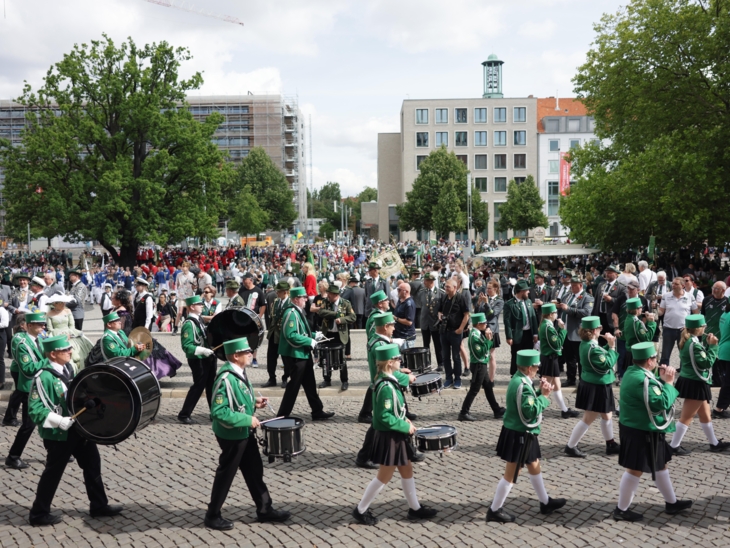 Blick auf einen Platz voller Menschen und Musikkapellen.