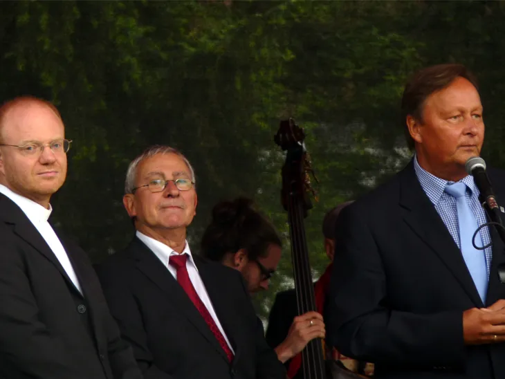 Ansprache des Bezirksbürgermeister Rödel auf der Bühne mit Pfarrer Dr. Kroh auf der 50 Jahr Feier der Kirche zu den Heiligen Engeln. 