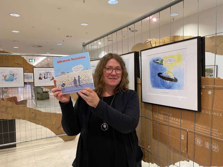 Eine Frau mit einer Karikatur in einer Ausstellung.