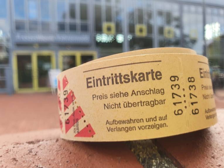 Eine Rolle mit Eintrittskarten auf einer Mauer vor dem Freizeitheim Vahrenwald im Hintergrund.