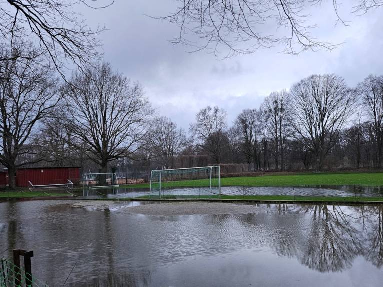 Sportplatz mit Fussballtoren, der Platz steht teilweise unter Wasser