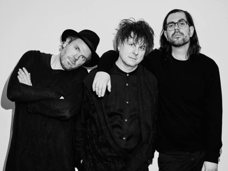 Zu sehen sind die drei Mitglieder der Band Klez.e. in einem Schwarz-Weiß-Foto.