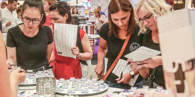 Frauen an einem Tisch mit vielen kleinen Behältern darauf.