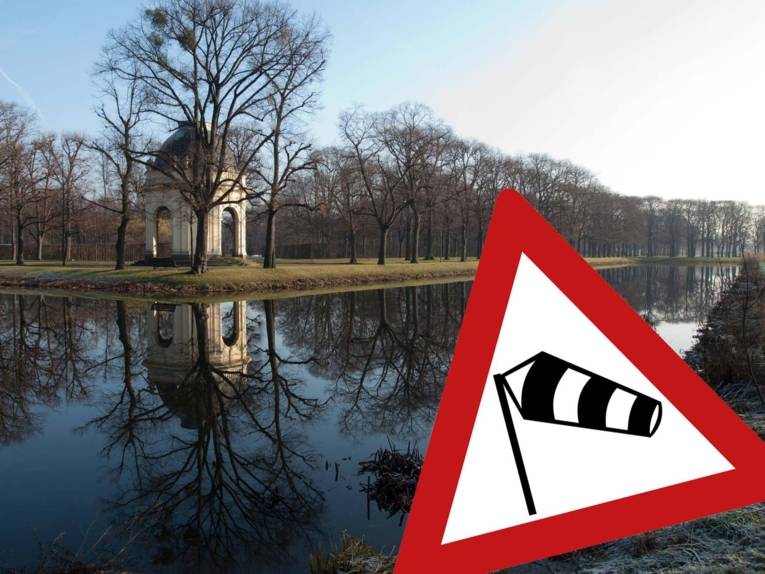 Ein Tempel. Davor Wasser. Ins Bild ist ein Zeichen montiert, das vor Sturm warnt.