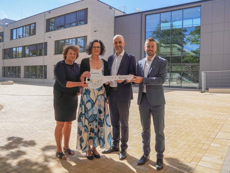 Vier Personen mit einem großen Schlüssel.