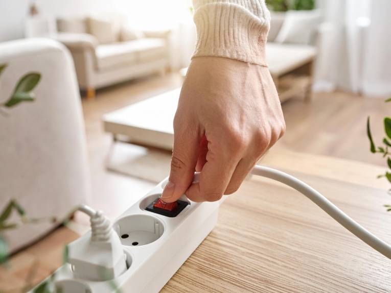 Schaltbare Steckerleiste, die von einer Hand aktiviert wird.