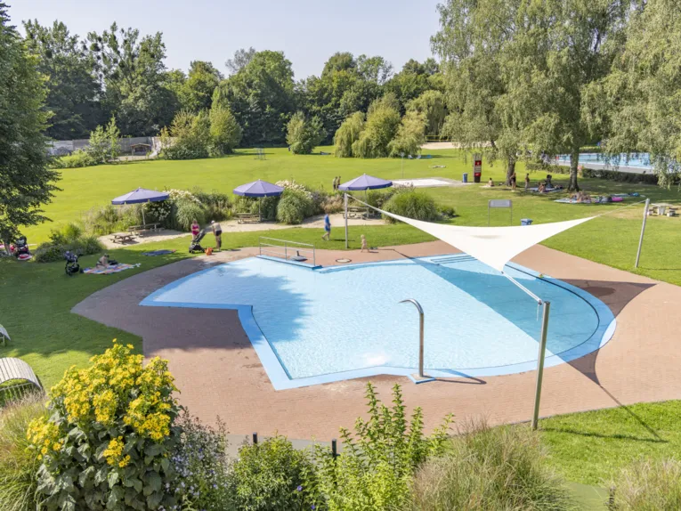 Flaches Becken in einem Freibad mit Sonnensegel &uuml;ber einem Teil des Beckens