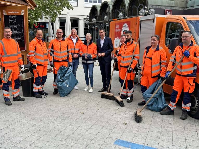 Eine Gruppe von Mitarbeitern der Stadtreinigung steht zusammen mit Axel von der Ohe, Robert Krause und Julia Fürst.