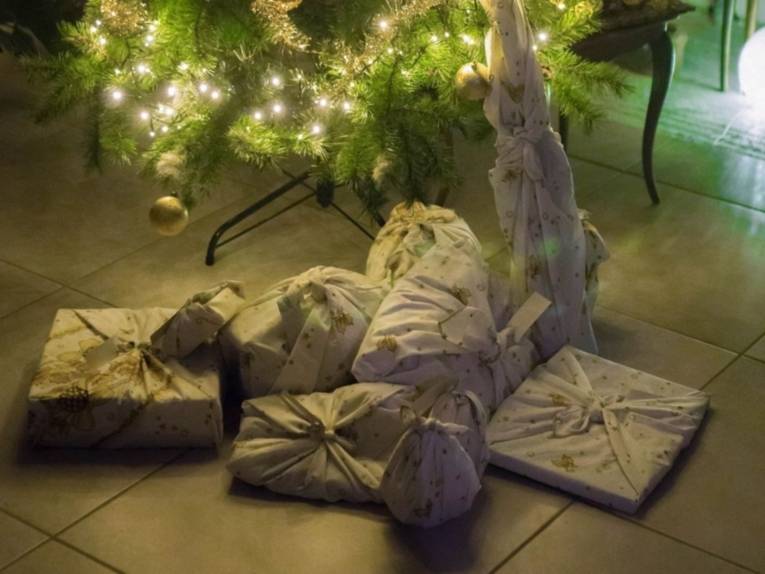 Geschenke, die verpackt unter einem Weihnachtsbaum liegen