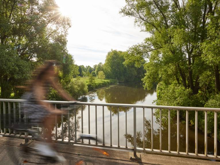 Radfahrerin auf einer Brücke
