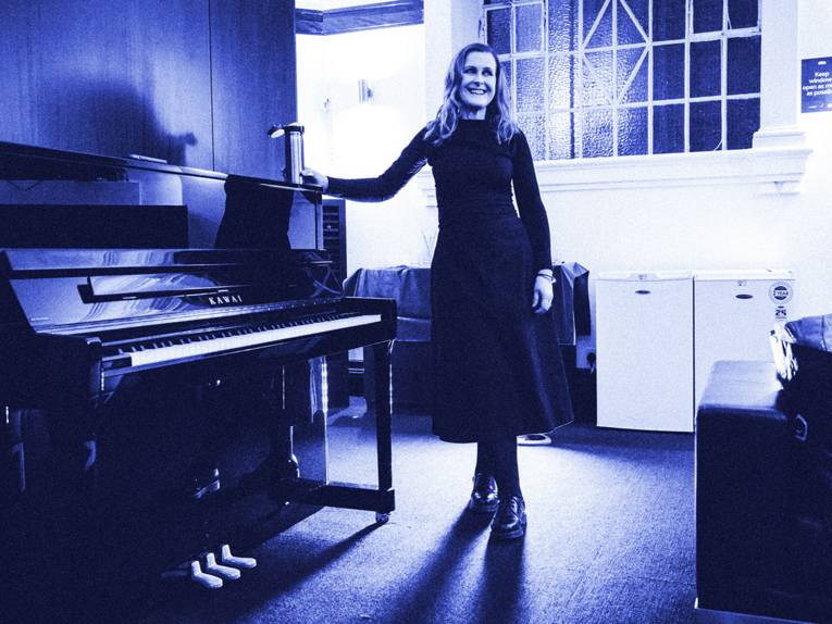 Alison Moyet steht neben einem Klavier.