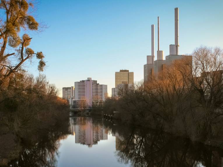 Blick auf ein Fluss mit kahlen Bäumen am Ufer, im Hintergrund das Ihmezentrum.