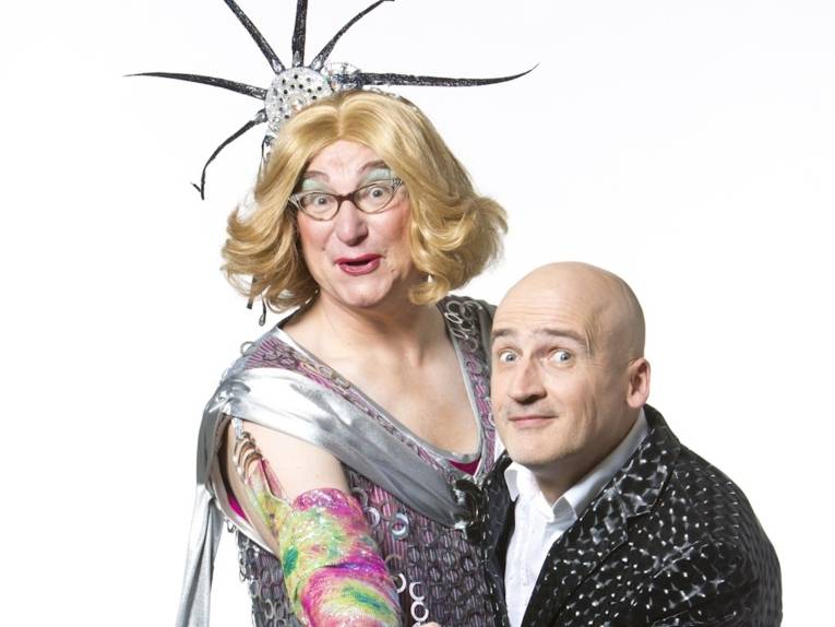 Zwei Männer, einer ist als schrille Frau verkleidet und geschminkt