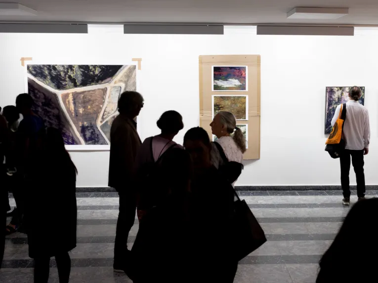 Publikum blickt auf Werke im Regionshaus, Schauplatz f&uuml;r Kunst. Die Bilder zeigen Menschen Topografie.