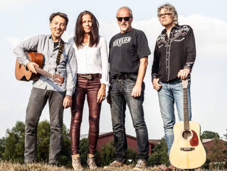 Eine Frau und drei Männer stehen nebeneinander, zwei Männer mit Gitarre