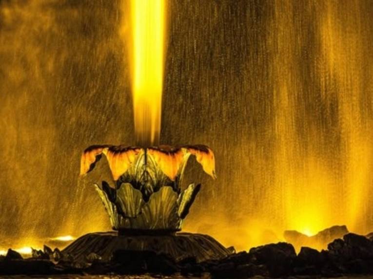 Zu sehen ist eine Nahaufnahme der Fontäne in den Herrenhäuser Gärten bei Nacht beleuchtet.