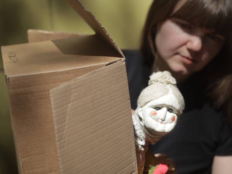 Puppenspielerin mit Puppe, die eine alte Dame darstellt.