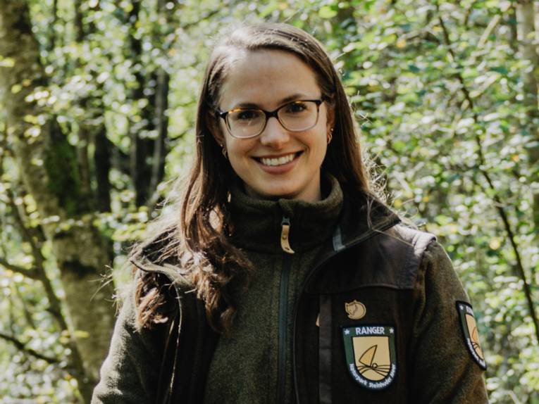 Eine Frau steht drau&szlig;en am Steinhuder Meer. Sie tr&auml;gt eine Fleece-Jacke mit der Aufschrift "Naturpark Ranger".