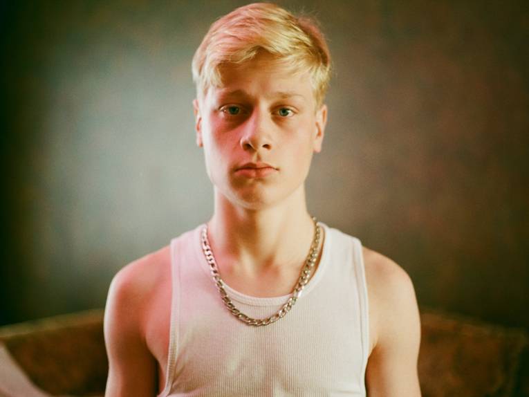 Ein blonder Teenager guckt in die Kamera