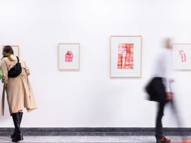 Publikum blickt auf Werke am Schauplatz f&uuml;r Kunst.