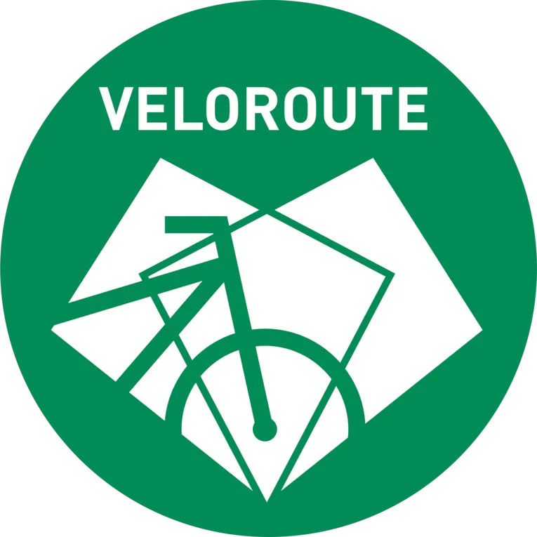 Ein grünes, rundes Logo. In den kreisrunden Logo ist ein weißes Fahrrad abgebildet und die Aufschrift Veloroute zu lesen.