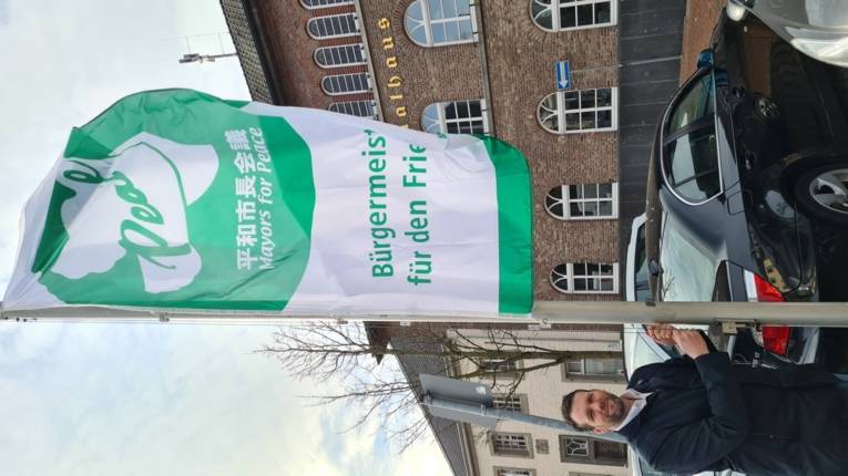 Bürgemeister Andreas Gisbertz hisst die Fahne der Mayors for Peace in der Gemeinde Schwalmtal
