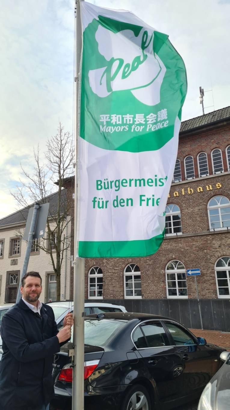Bürgemeister Andreas Gisbertz hisst die Fahne der Mayors for Peace in der Gemeinde Schwalmtal