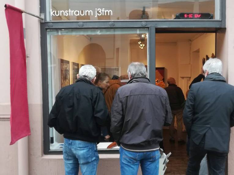 Menschen stehen vor und im Kunstraum j3fm