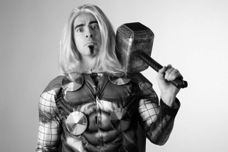 Schwarzweiß-Bild eines langhaarigen Mannes in Thor-Kostüm.