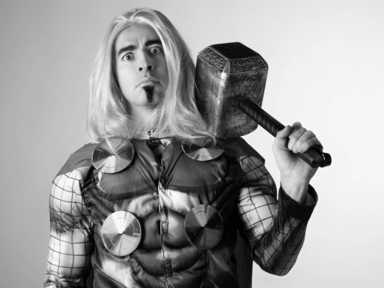 Schwarzweiß-Bild eines langhaarigen Mannes in Thor-Kostüm.
