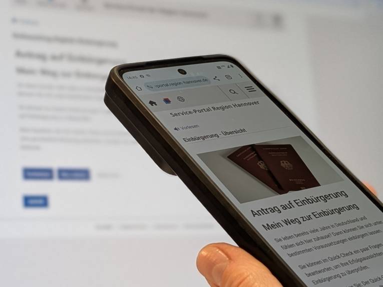 Ein Smartphone mit einer Anwendung vor einem Bildschirm