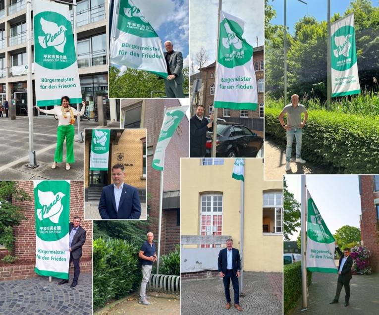 Neun Bürgermeisterinnen und Bürgermeister des Kreises Viersen präsentieren die Flagge der Mayors for Peace in ihren Städten und Gemeinden