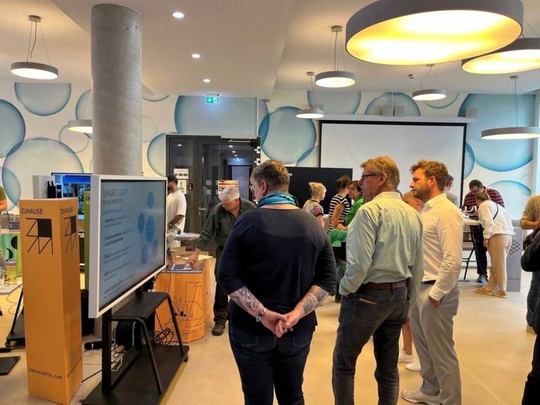 Menschen blicken auf einen Bildschirm.