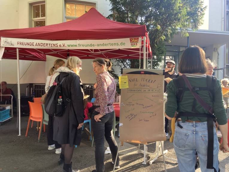 Personen die sich angeregt unterhalten. Ein Plakat mit Ideensammlungen