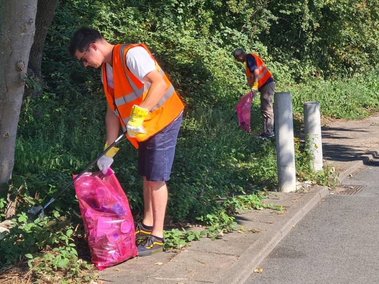 Zwei freiwillige Männer, die bei der Müllaktion mitwirken.